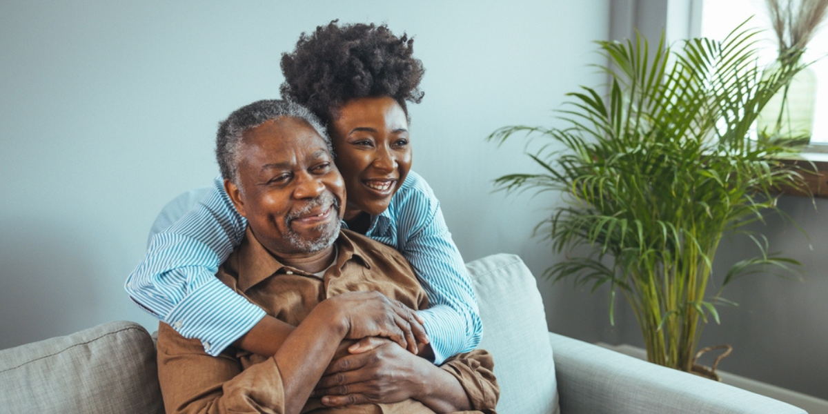 Photo of older and young adults hugging.