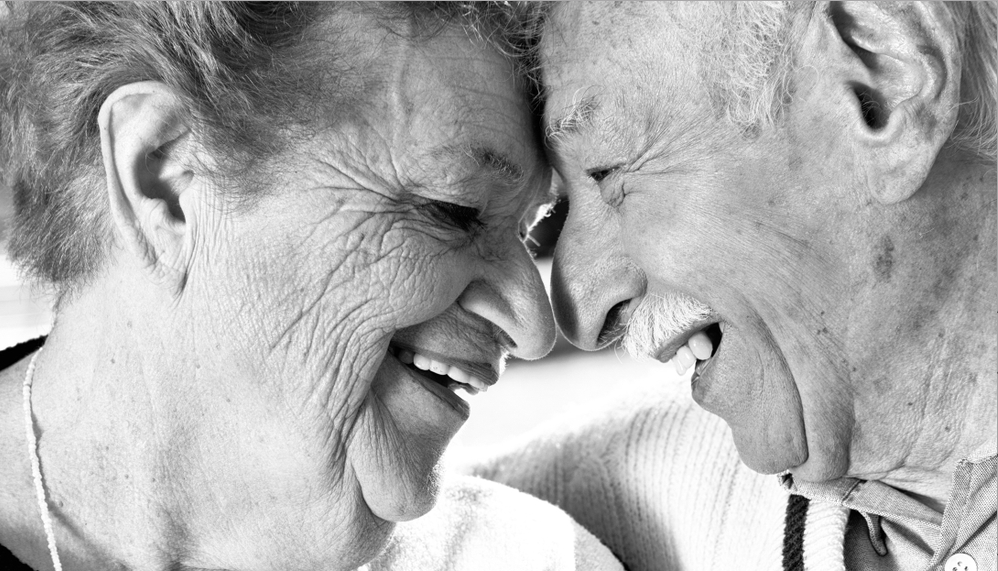 close up black and white image of a white couple smiling at each other