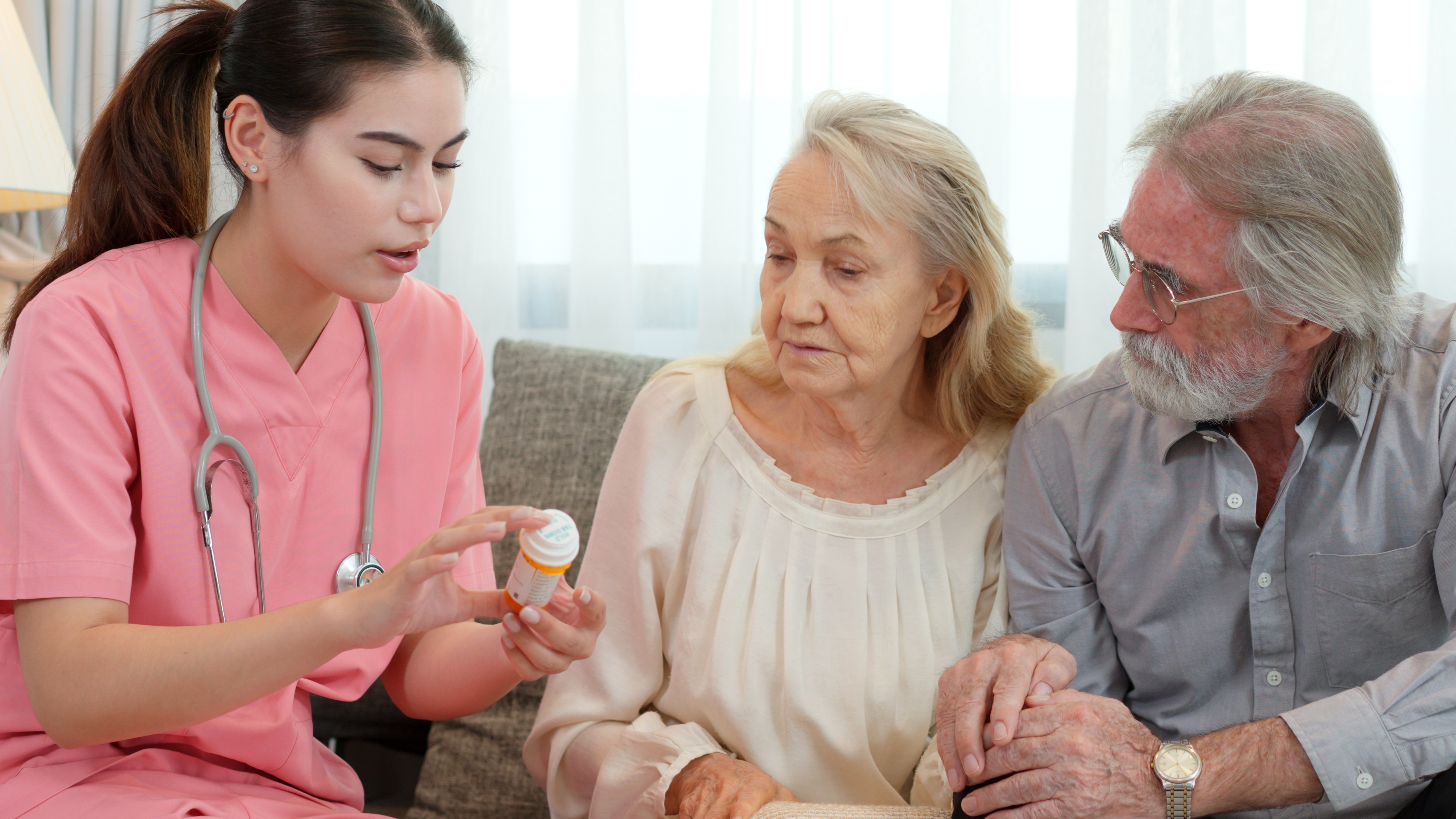 Nurse explaining medication to older patient and family member